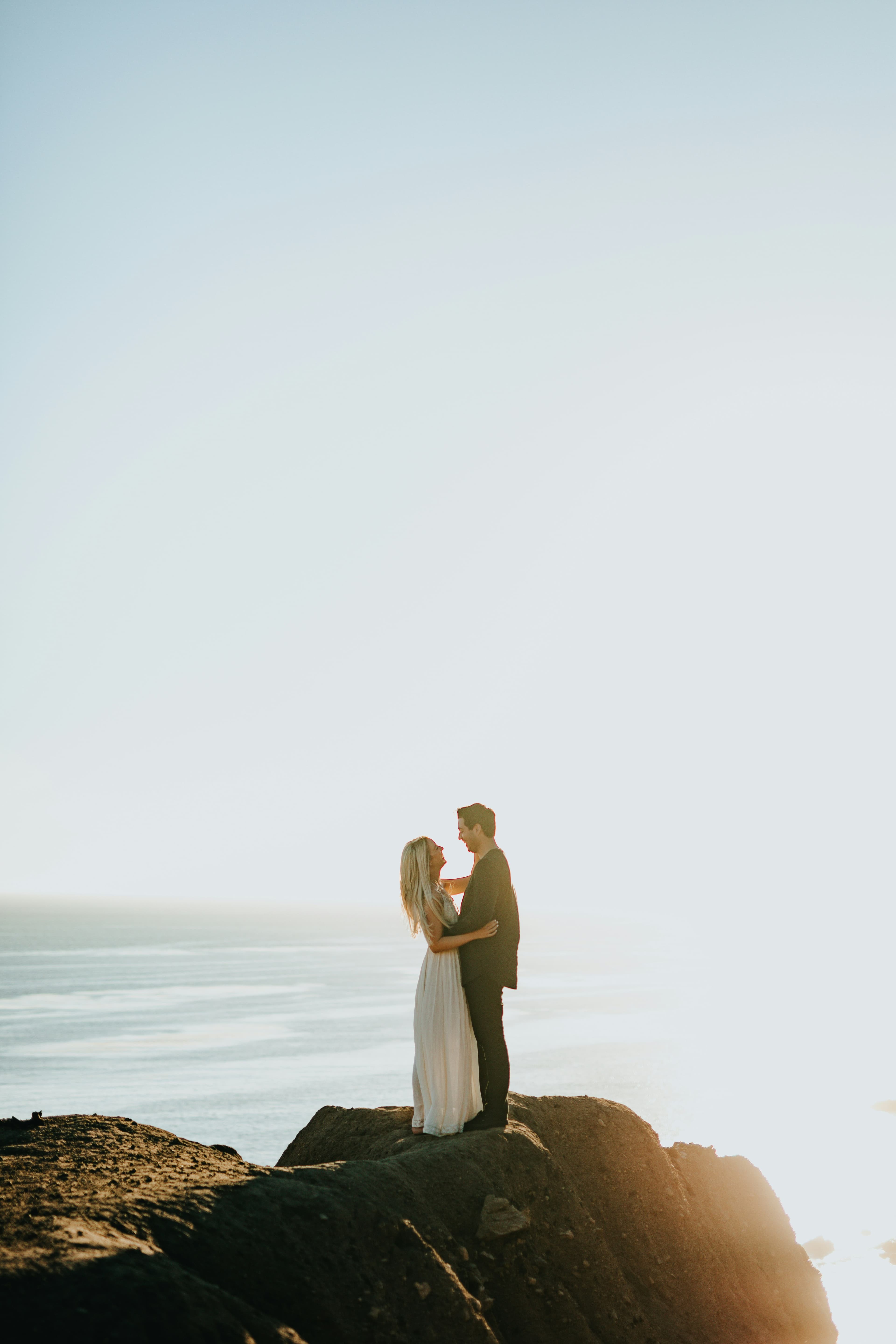 Couple standing together on a sunlit rock formation